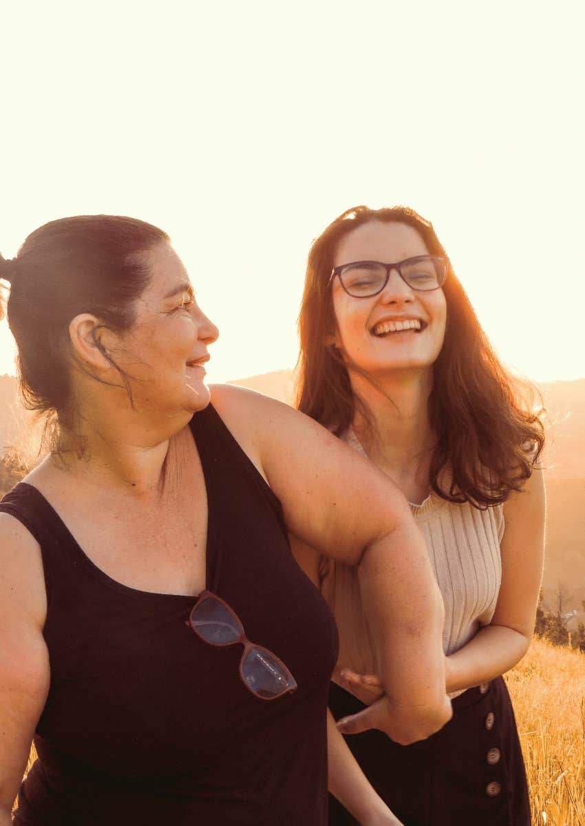playful mother and adult daughter laughing together