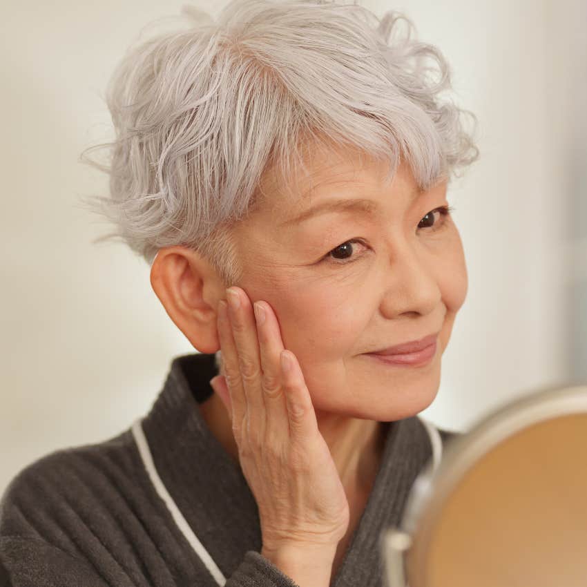 happy woman slowing down daily rituals while doing her skincare