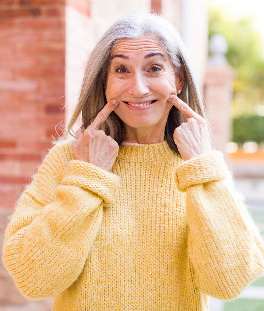 happy person points to smile showing learned change without stress