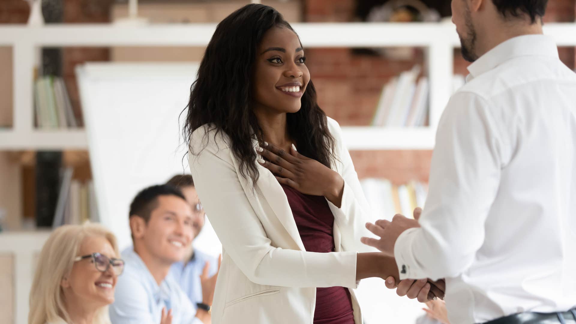 worker thanking her boss shaking hands