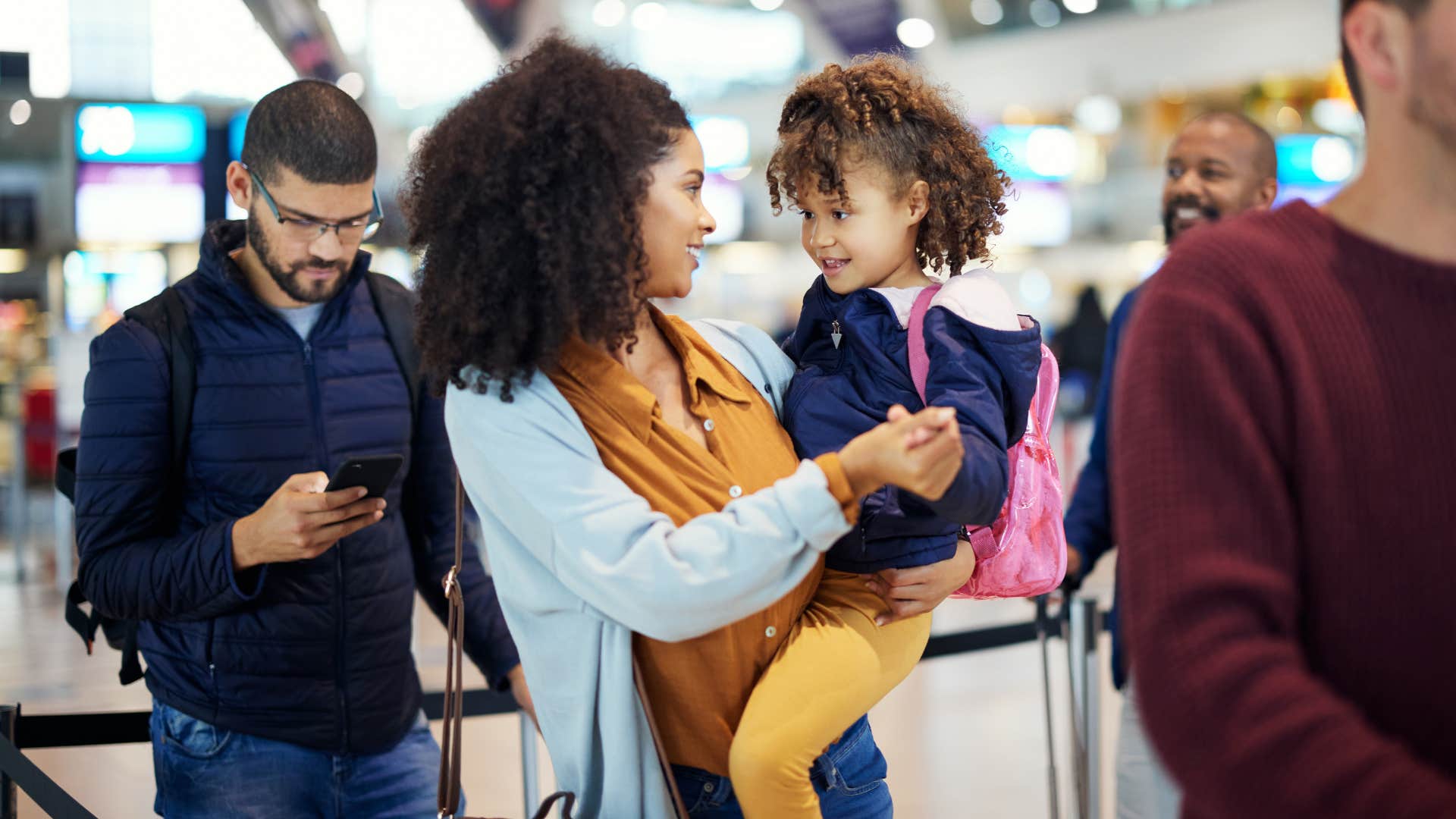 woman giving her daughter a good upbringing waiting in line