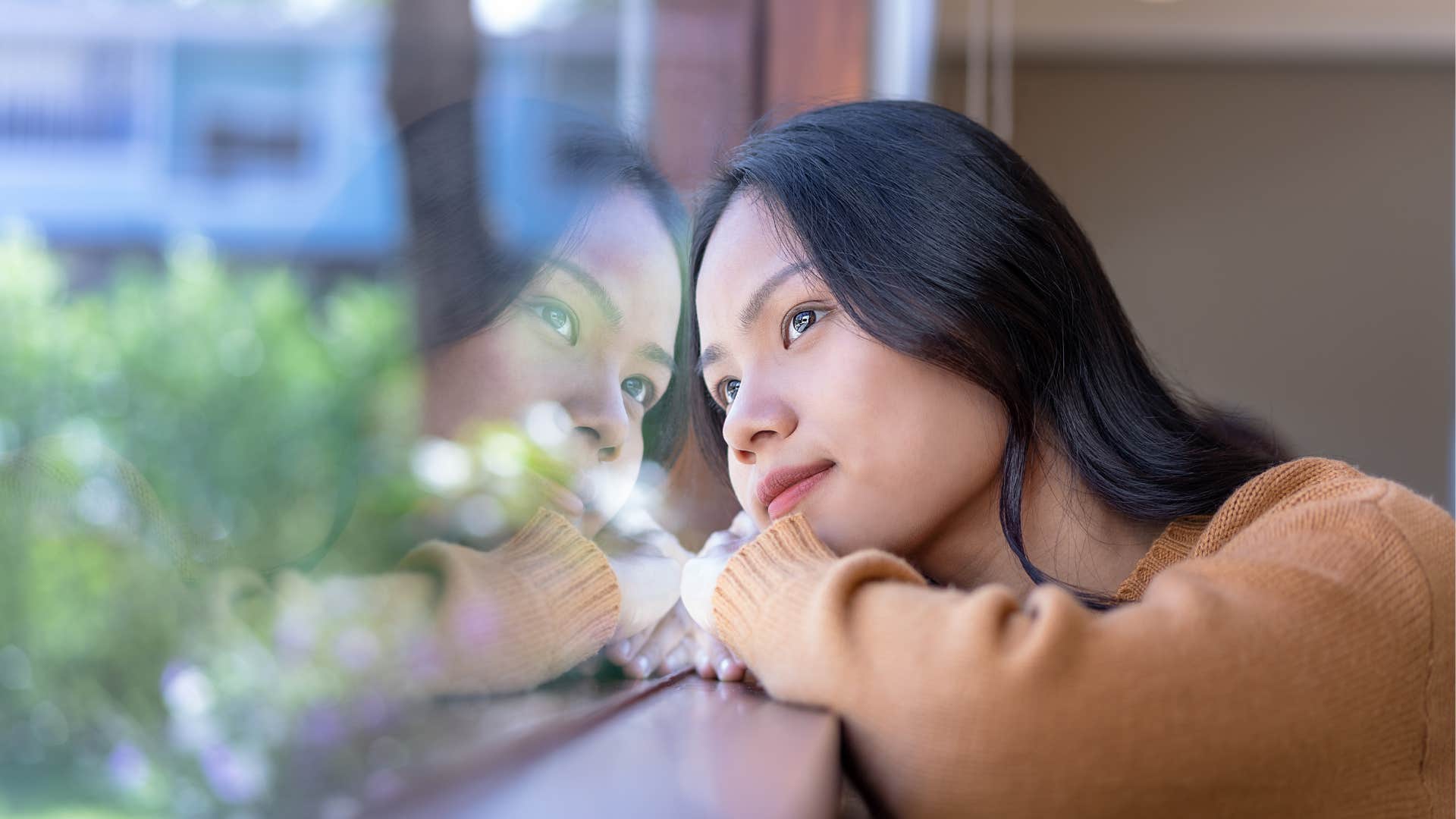 Woman who has a beautiful soul looking out the window peacefully 