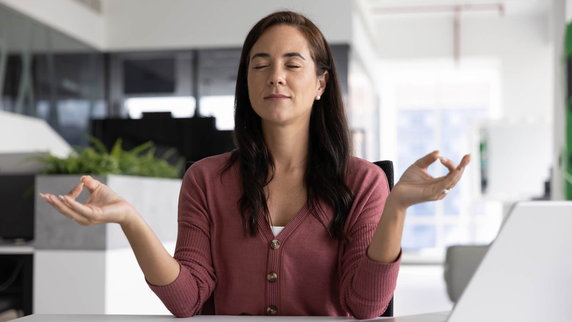 emotionally regulated woman meditating at work