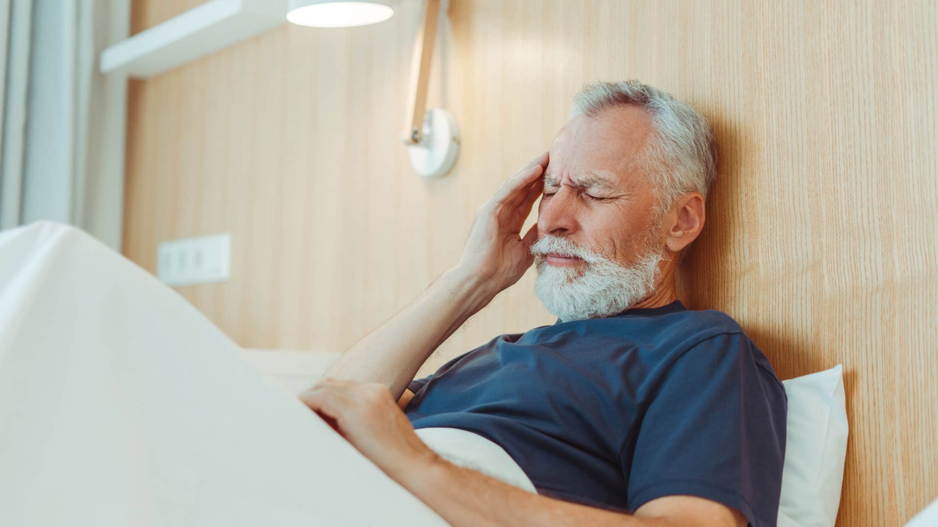 man with limited energy sitting up in bed