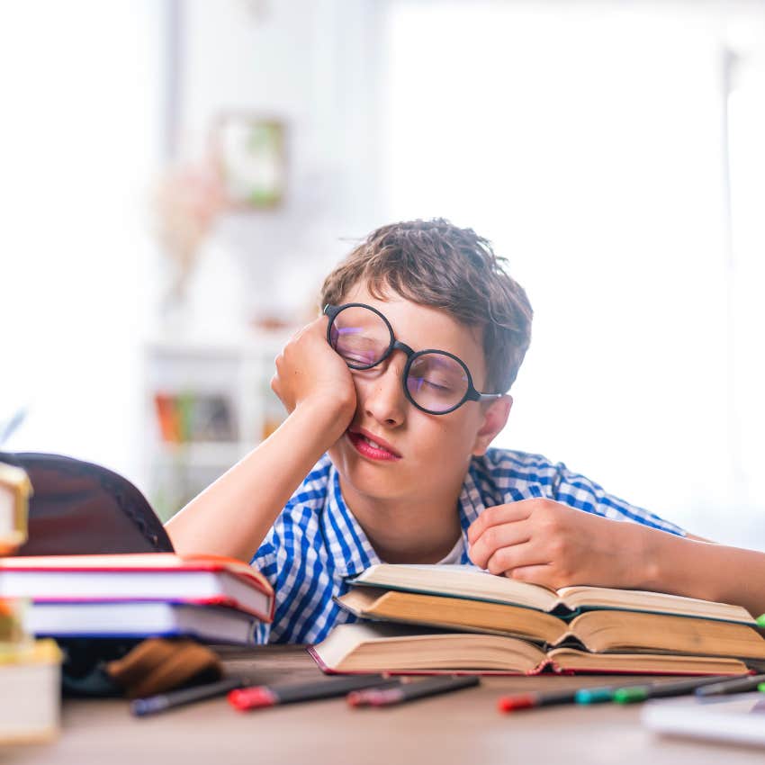 tired kid with a strict and busy schedule falling asleep while reading