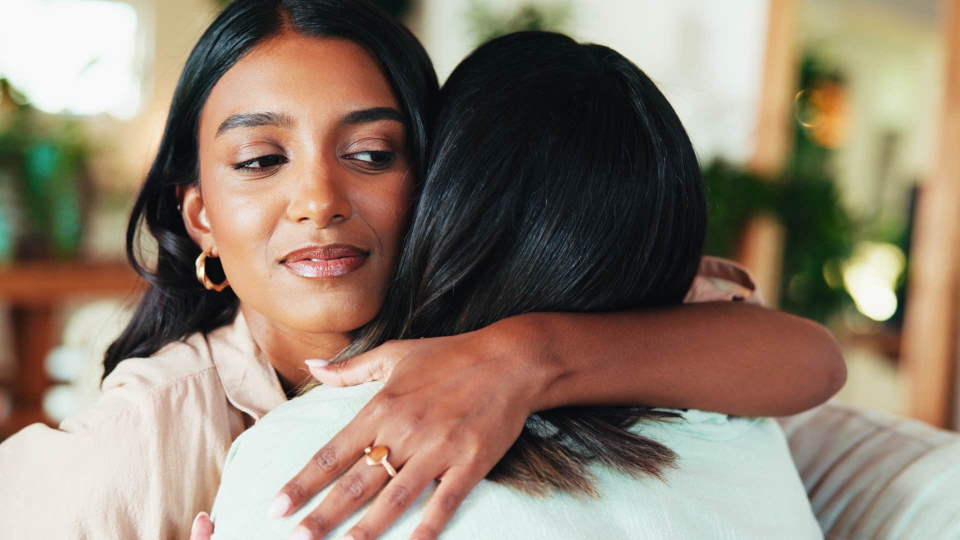 woman living in a jealous culture hugging her friend reluctantly