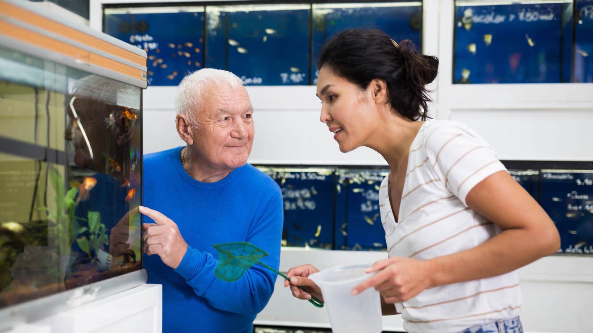 man selling woman a fish at the pet store