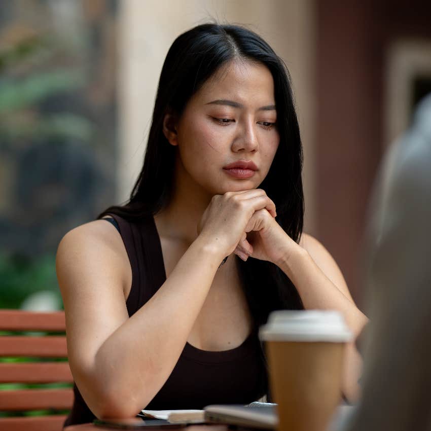 serious woman with cup of coffee on table