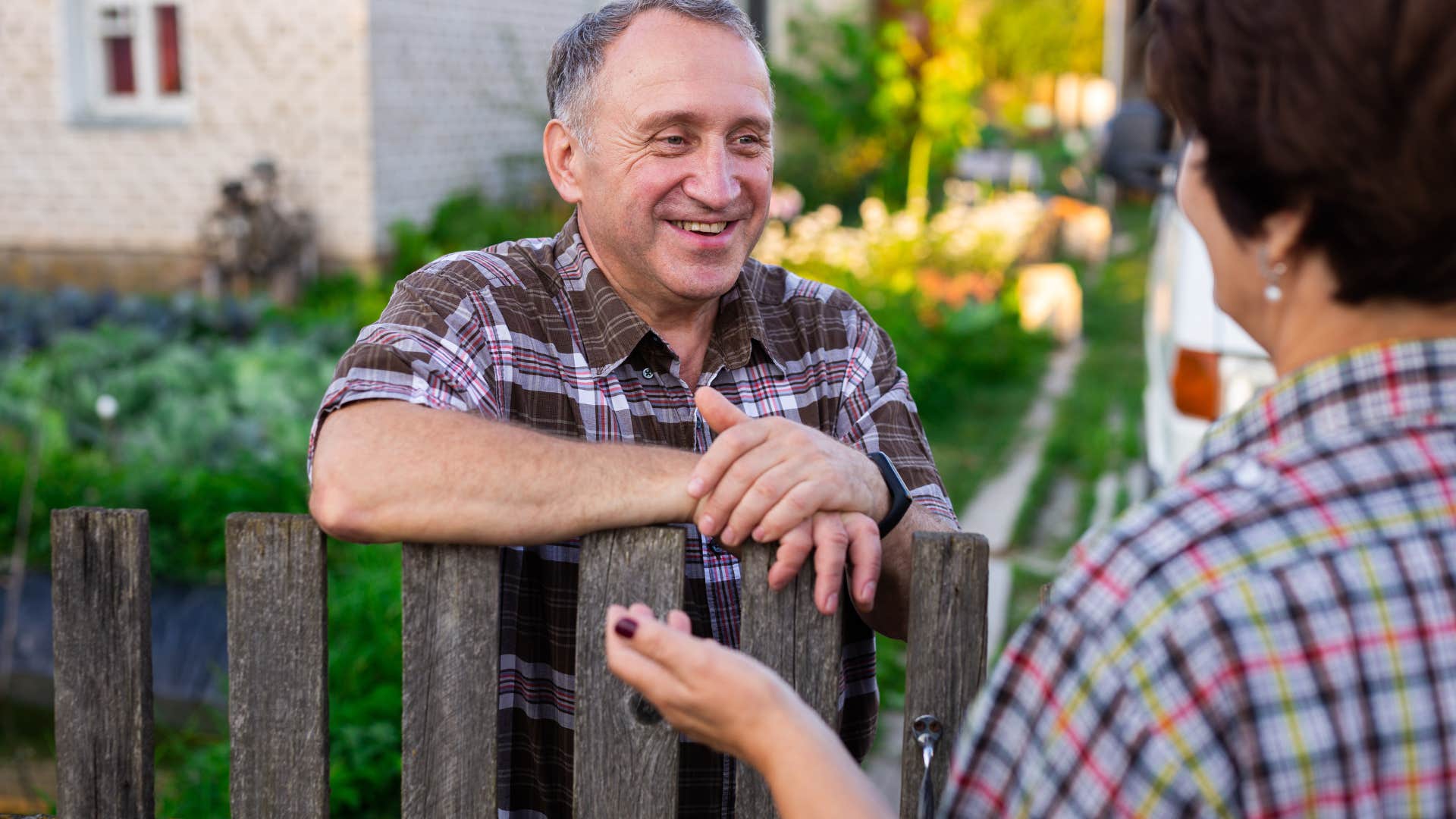 friendly man over 60 talking to his neighbor smiling