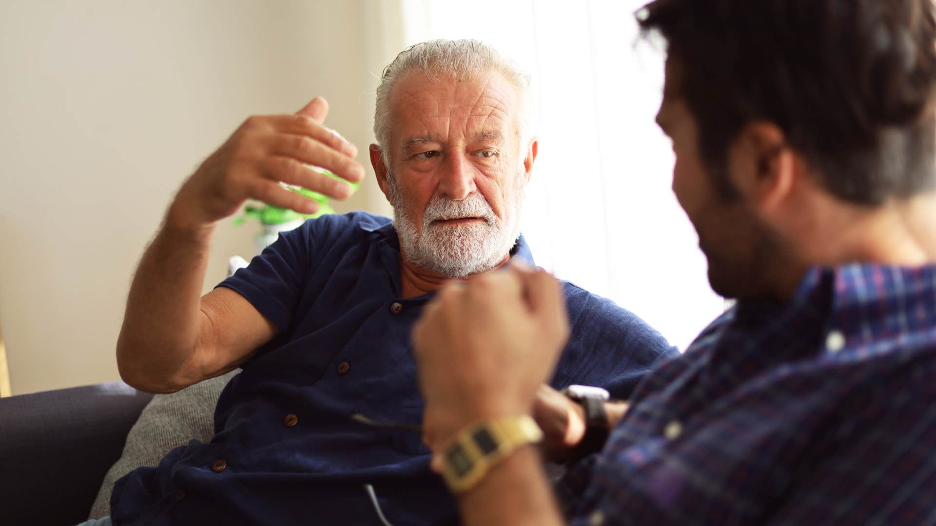 older father scolding his adult son saying i had it harder when i was your age