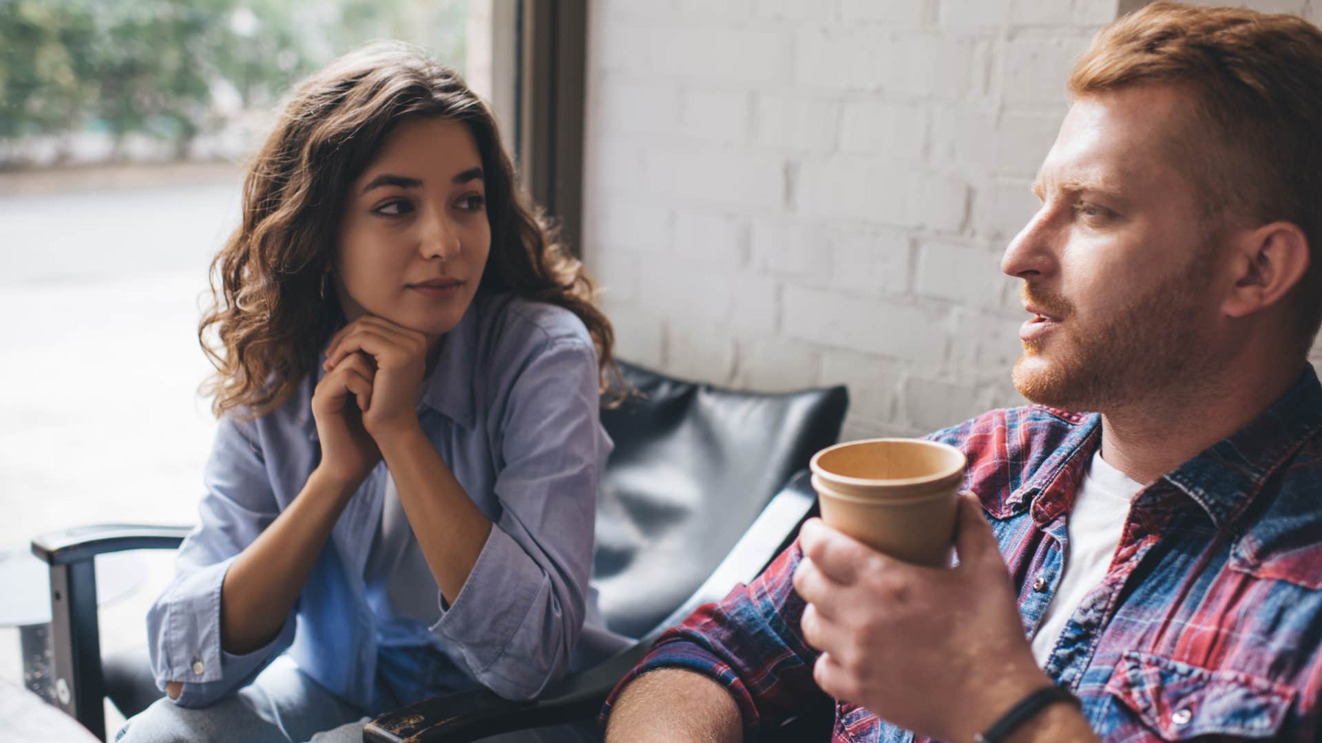 man making a bad first impression on a date by avoiding eye contact with woman