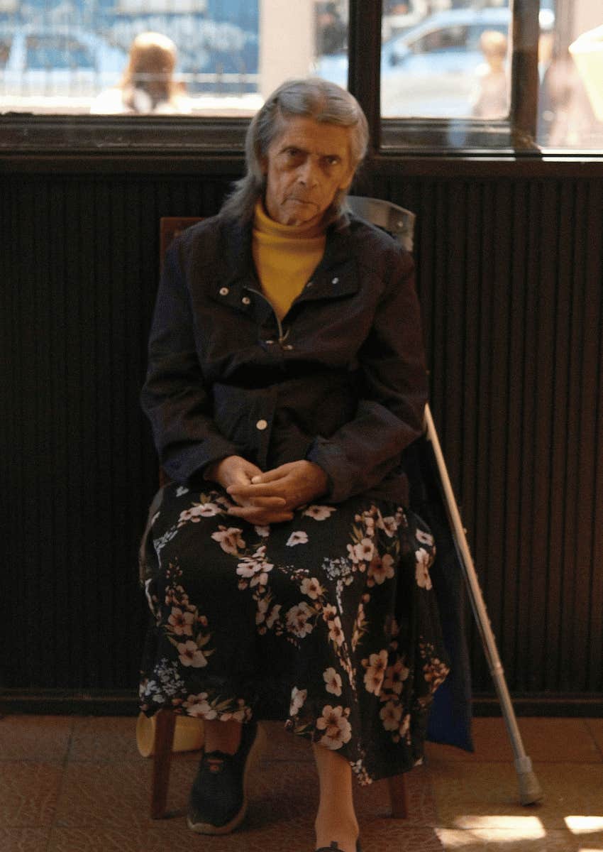 serious older woman sitting alone 