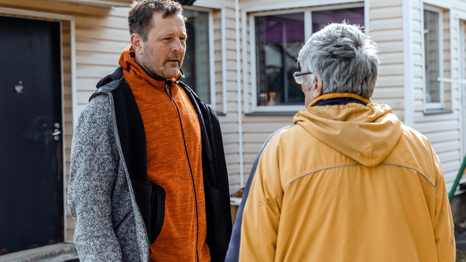 Man talking to his mother who gets defensive when he offers help.