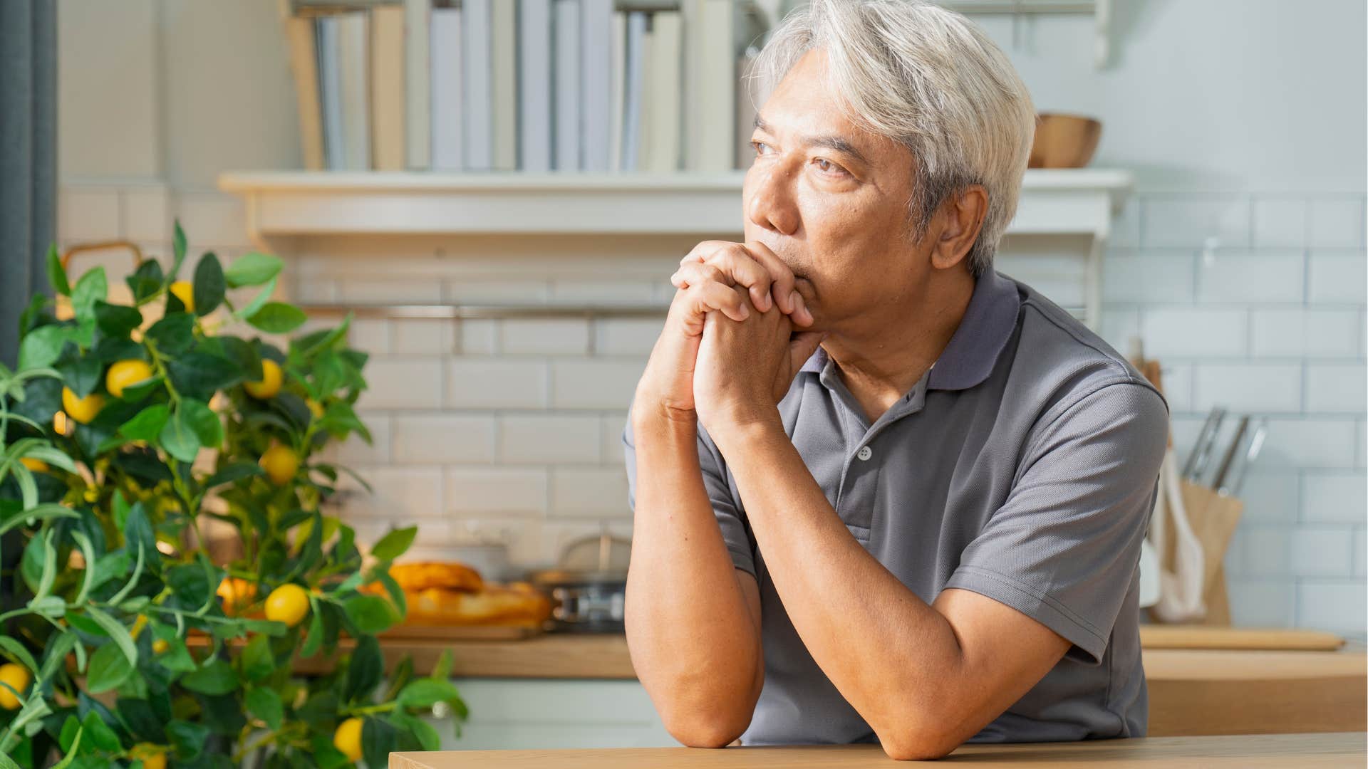 Man whose mood has seriously shifted sitting alone at home.