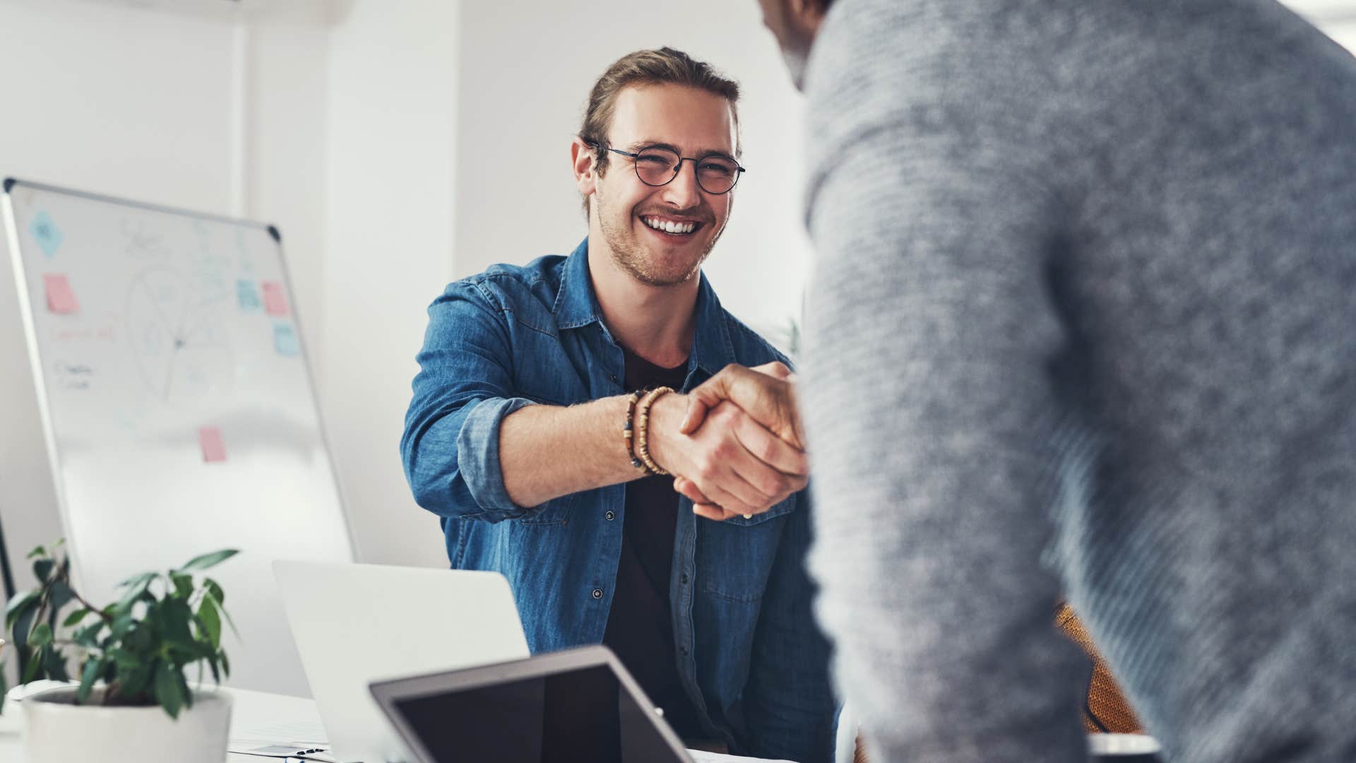 man who doesn't rehearse conversations shaking hands with colleague