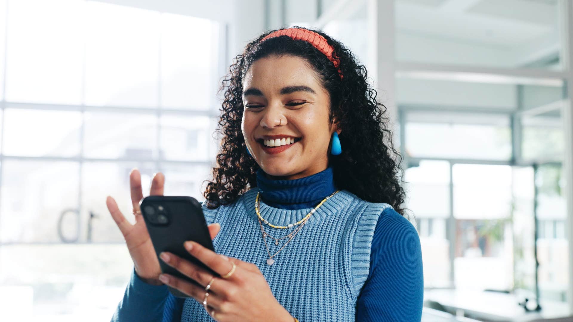 smiling woman leaning into challenges using her phone