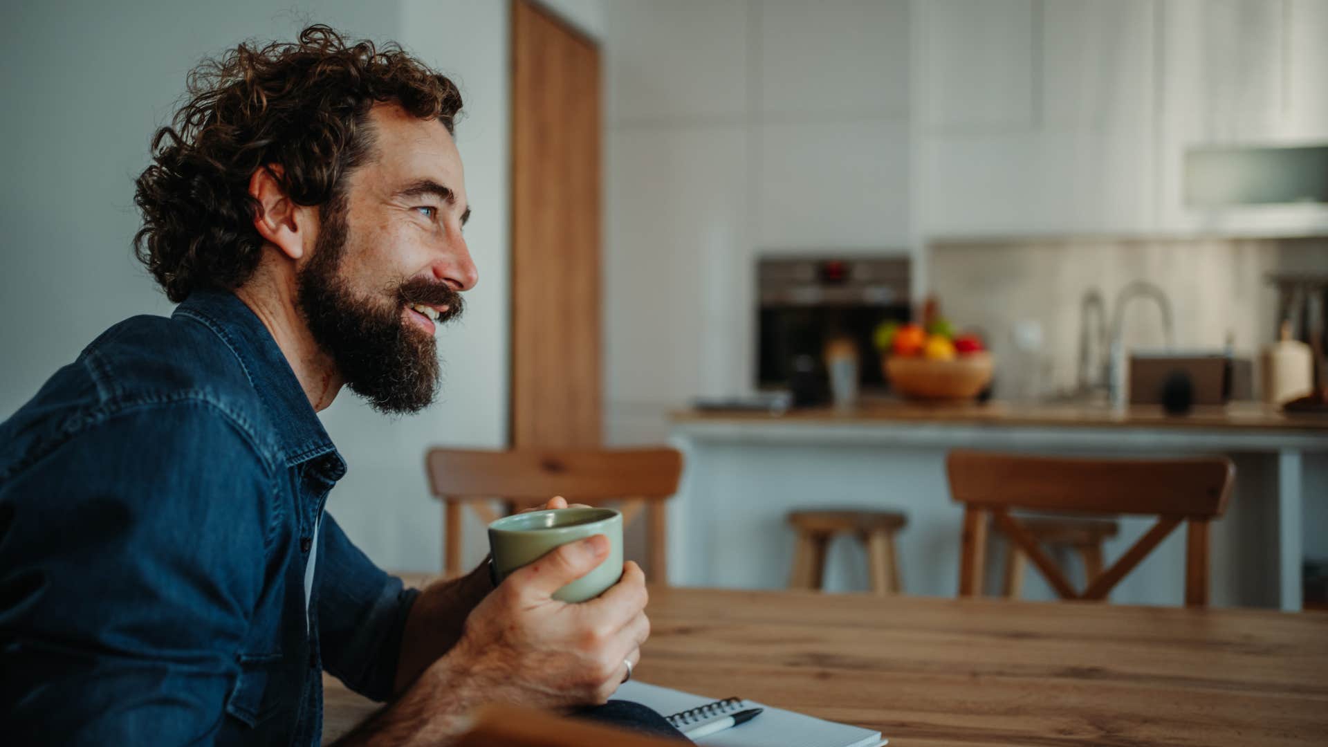 smiling intelligent simplifying his routine drinking morning coffee