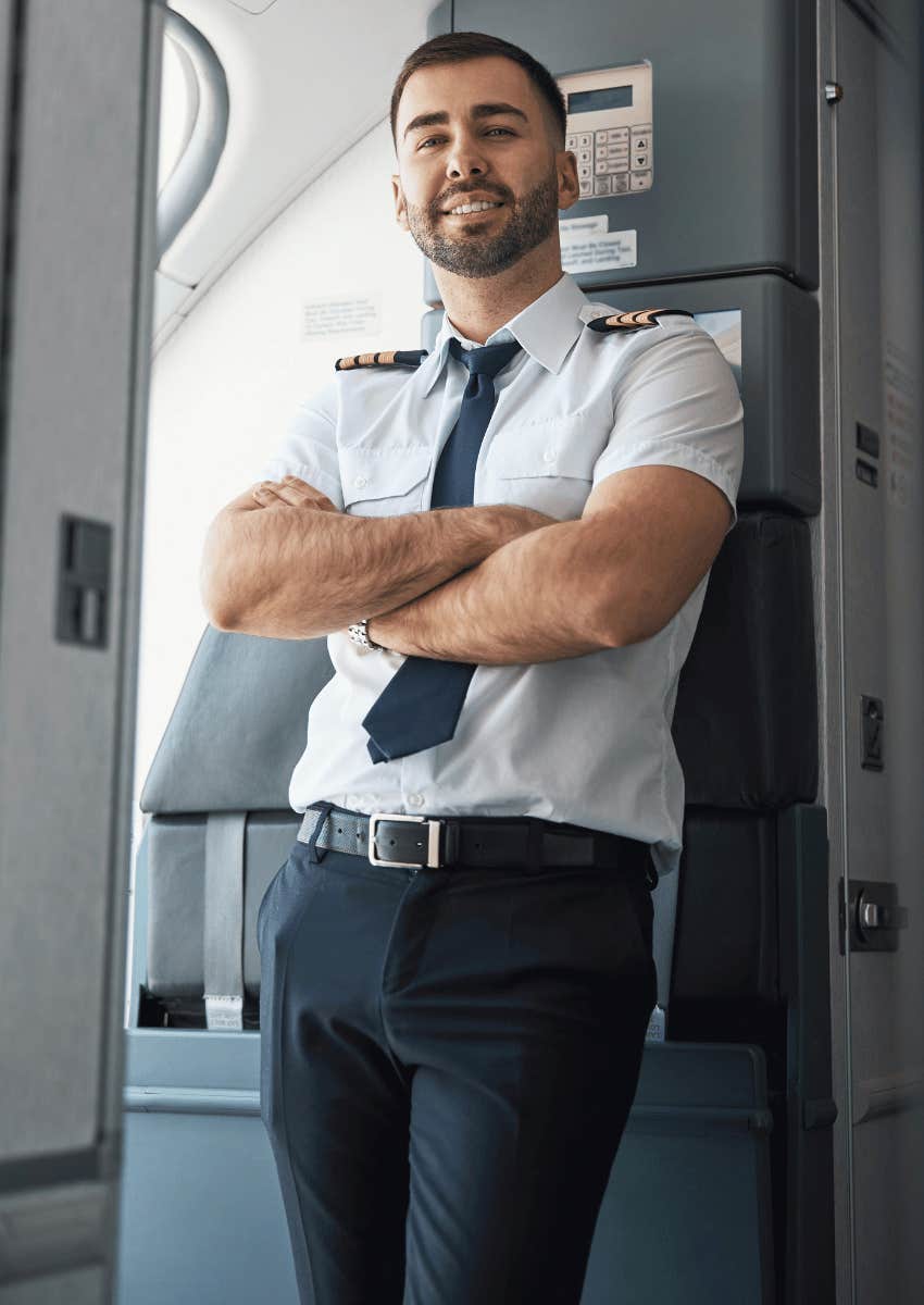 smiling flight employee standing at airplane door