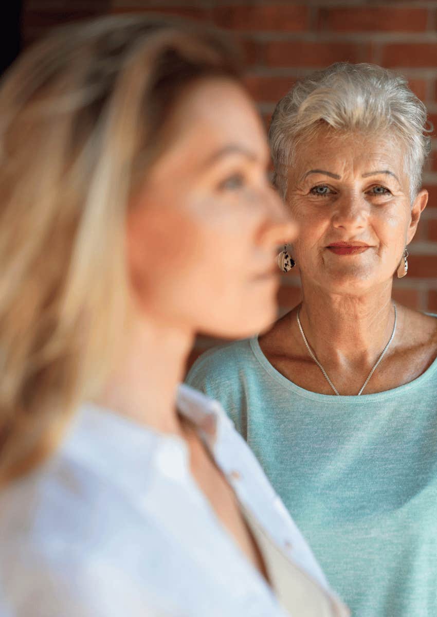 smiling senior woman looking at the blurry profile of a younger woman