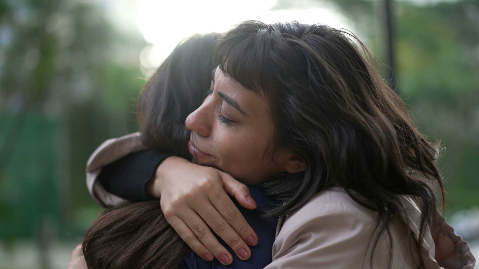 woman with a gold heart accepting friend for who they are hugging her