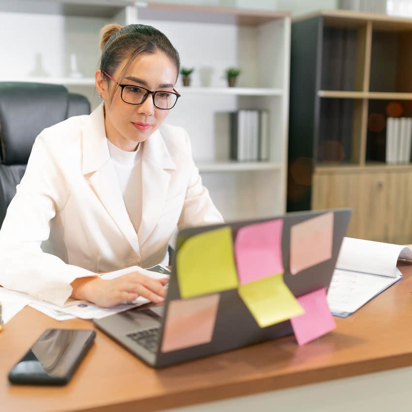 high-iq woman staying busy to avoid her emotions working on laptop
