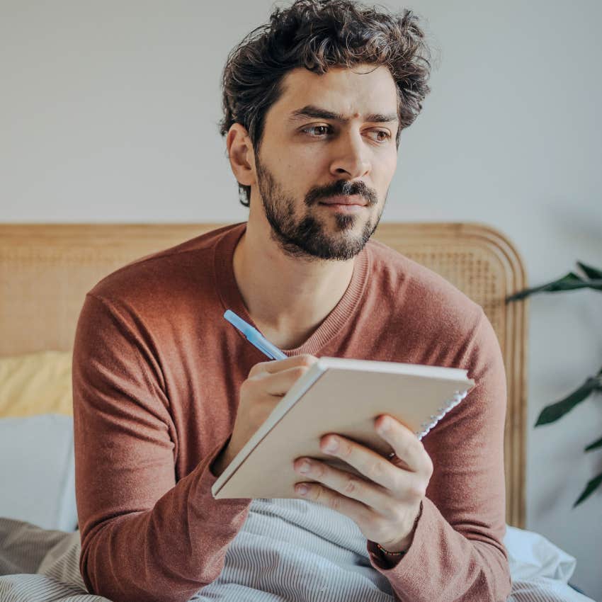 Man using a scripting method in his journal at home