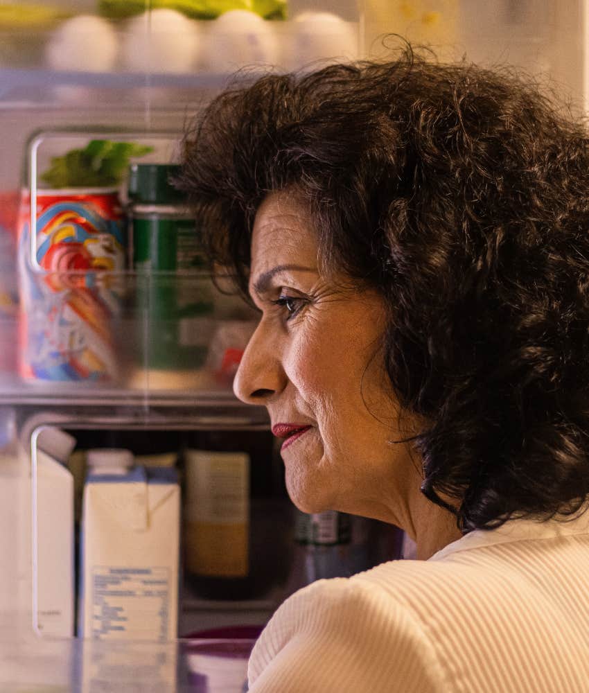 dissatisfied older woman looks in refrigerator showing appetite change
