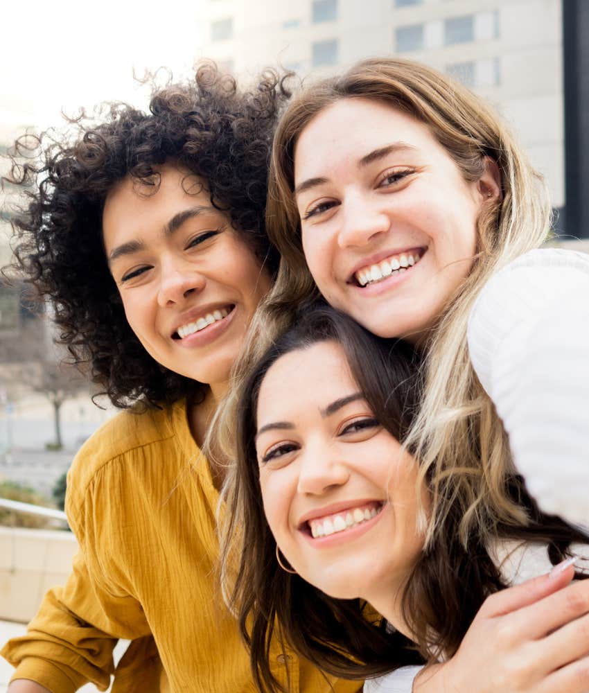 three happy people embrace showing having friends is possible