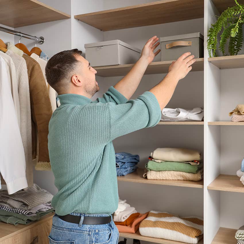 man organizing his closet with bins