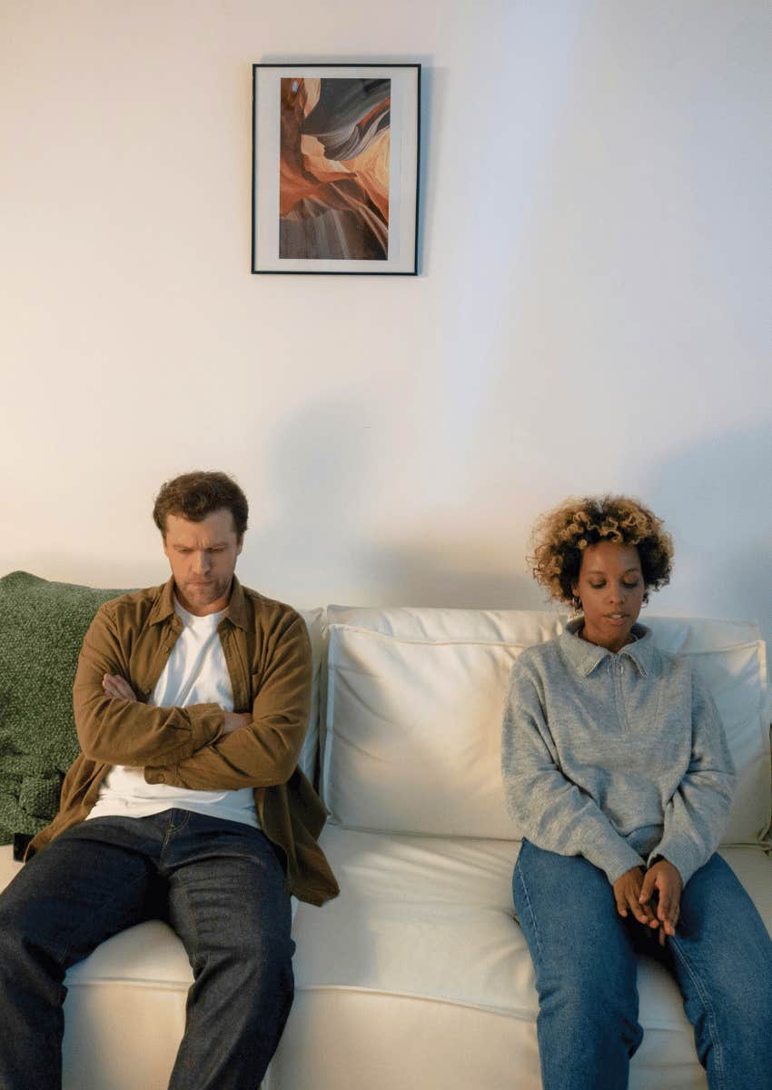 tense couple sitting apart on couch