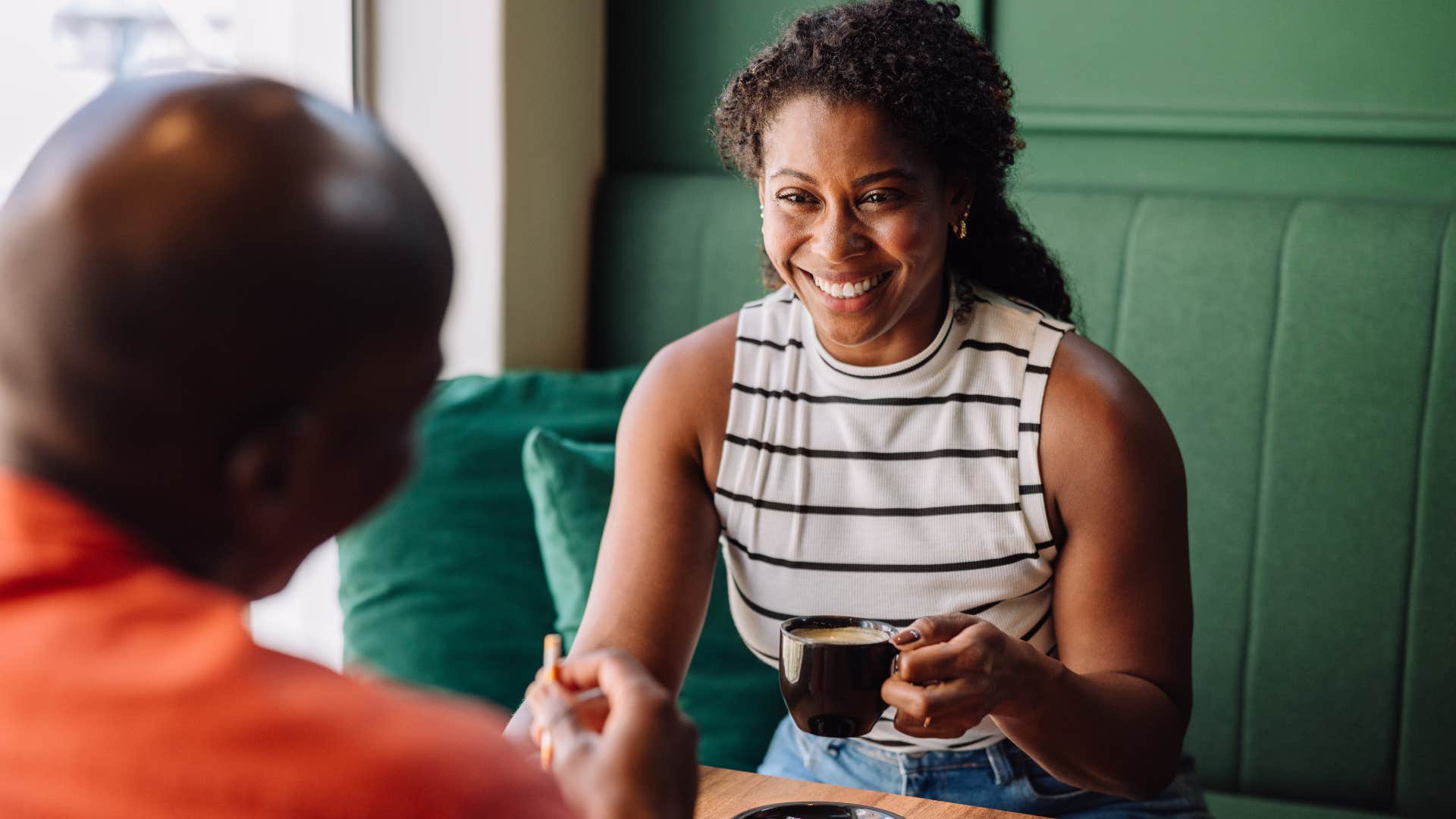 american woman sitting at brunch across from man