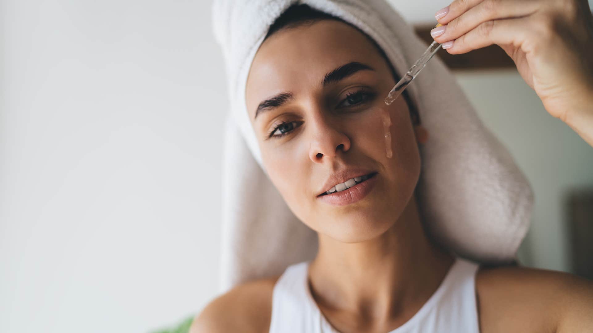american woman doing skincare routine with serum