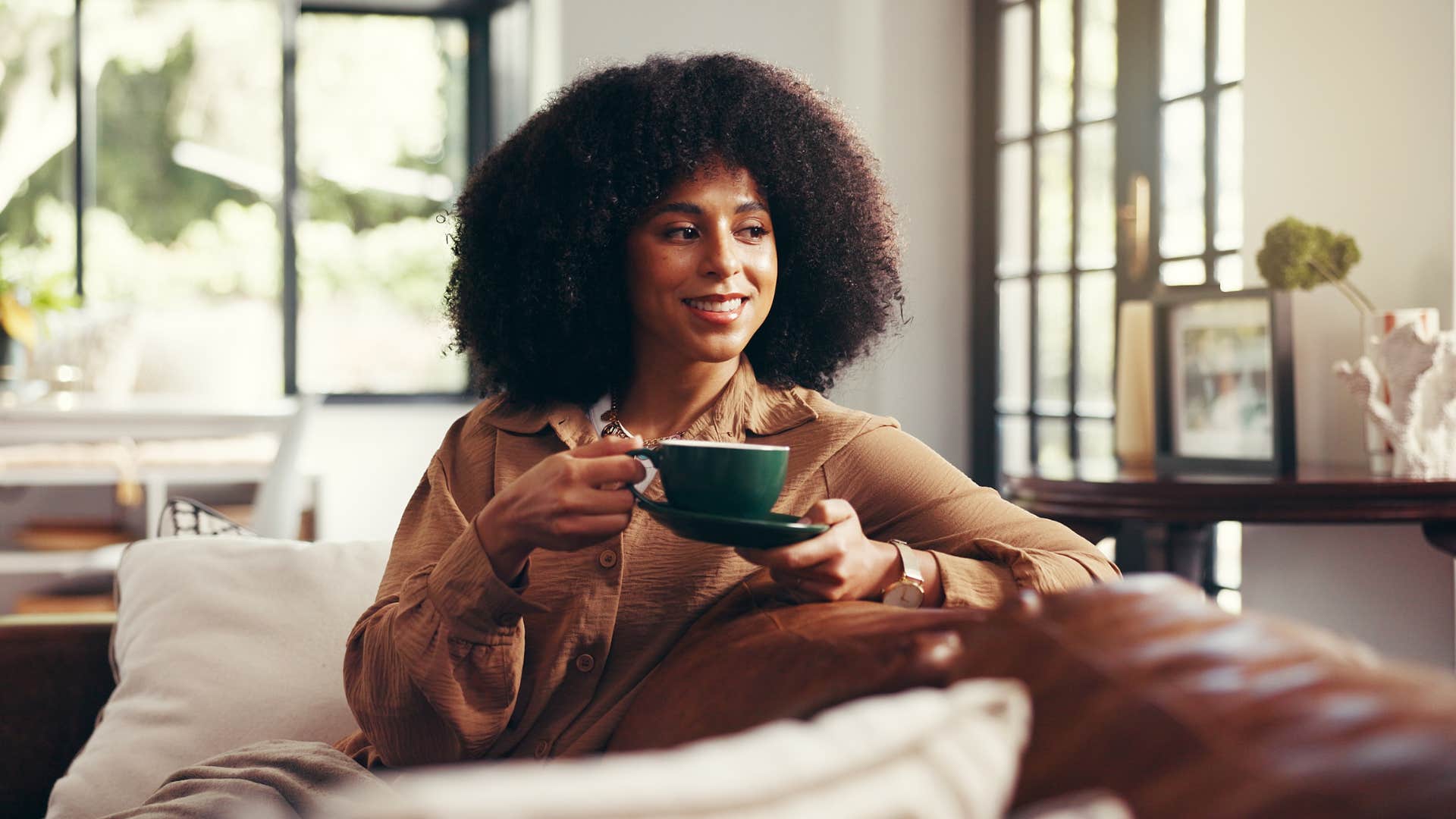 ameircan woman siting on couch drinking coffee