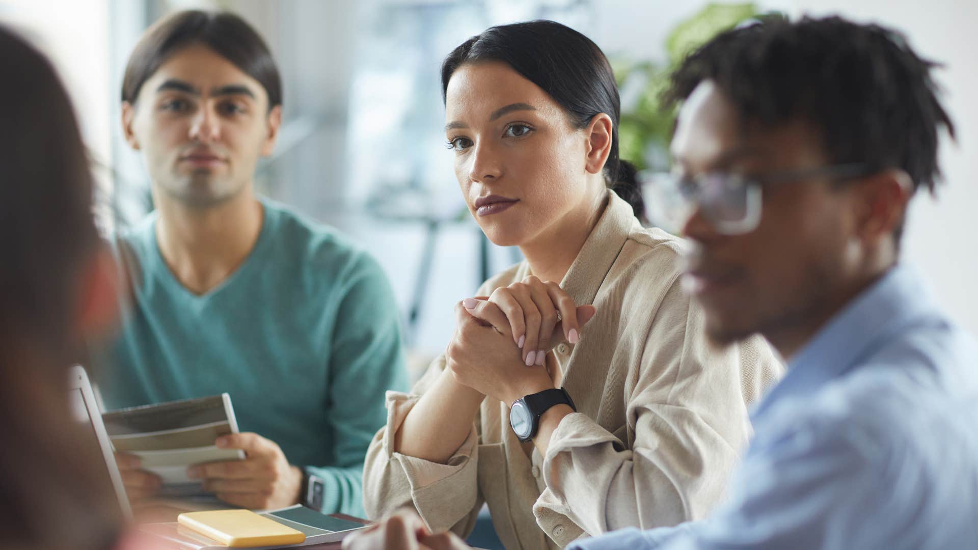 group of gen z colleagues listening to boss talk about company loyalty