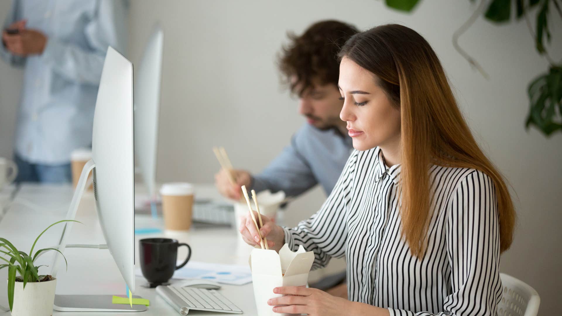 stressed gen z employee working while she eats lunch