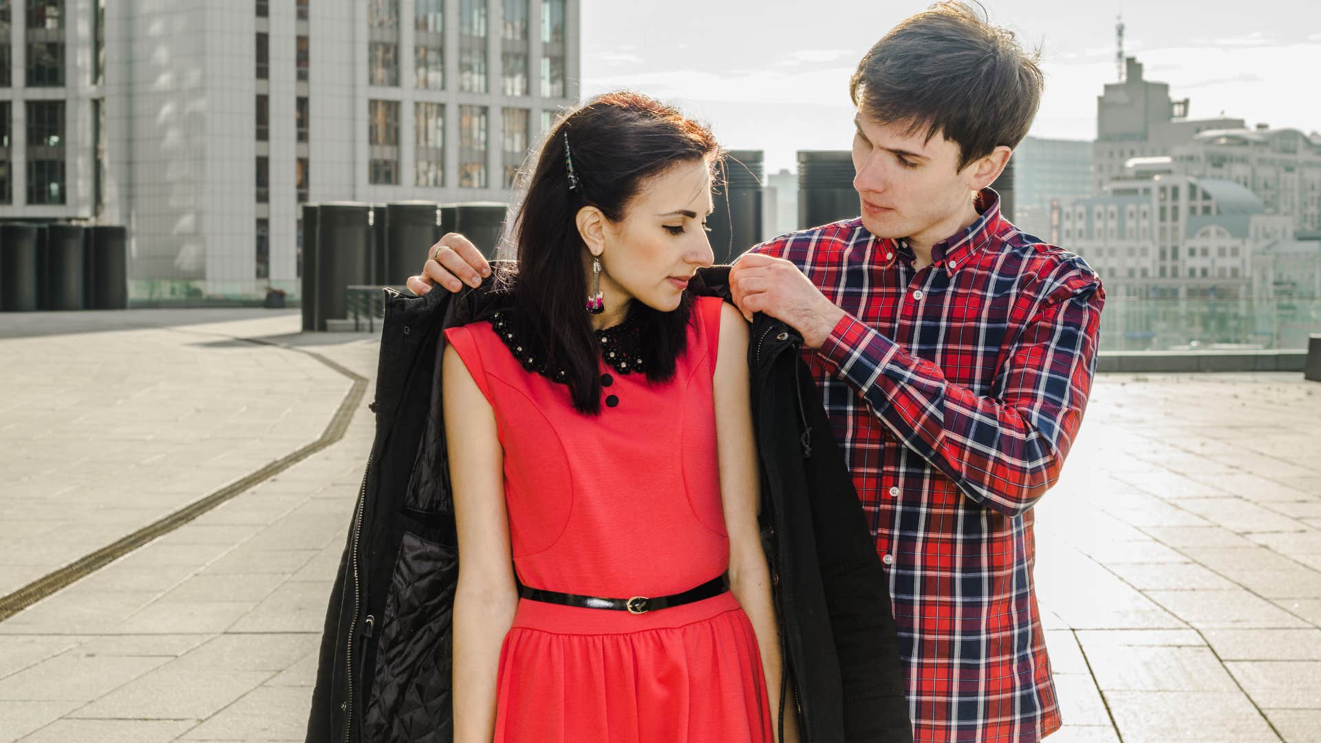 man letting his girlfriend wear his coat when she's cold