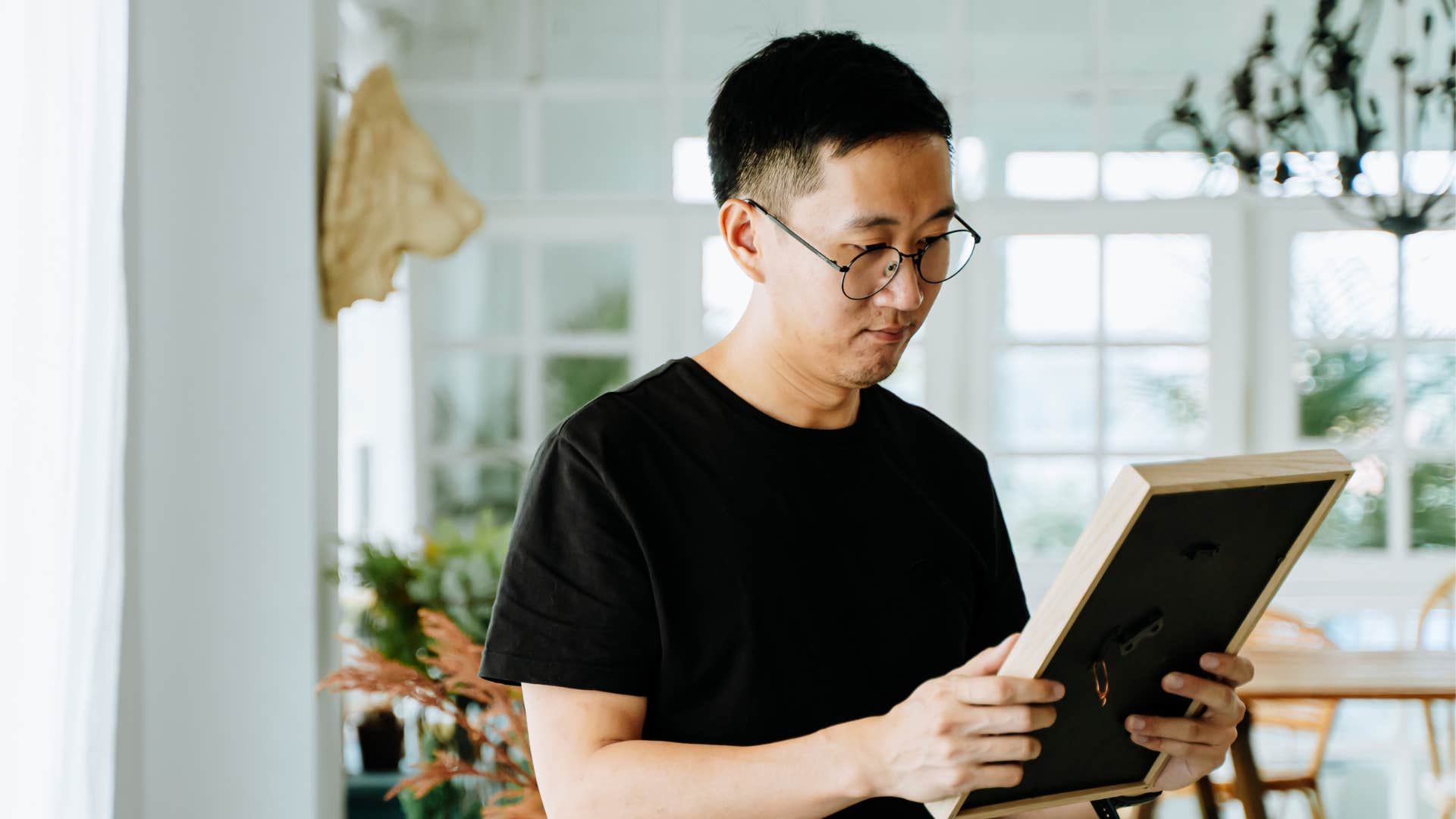 man questioning his relationship looking at photo of him and his partner