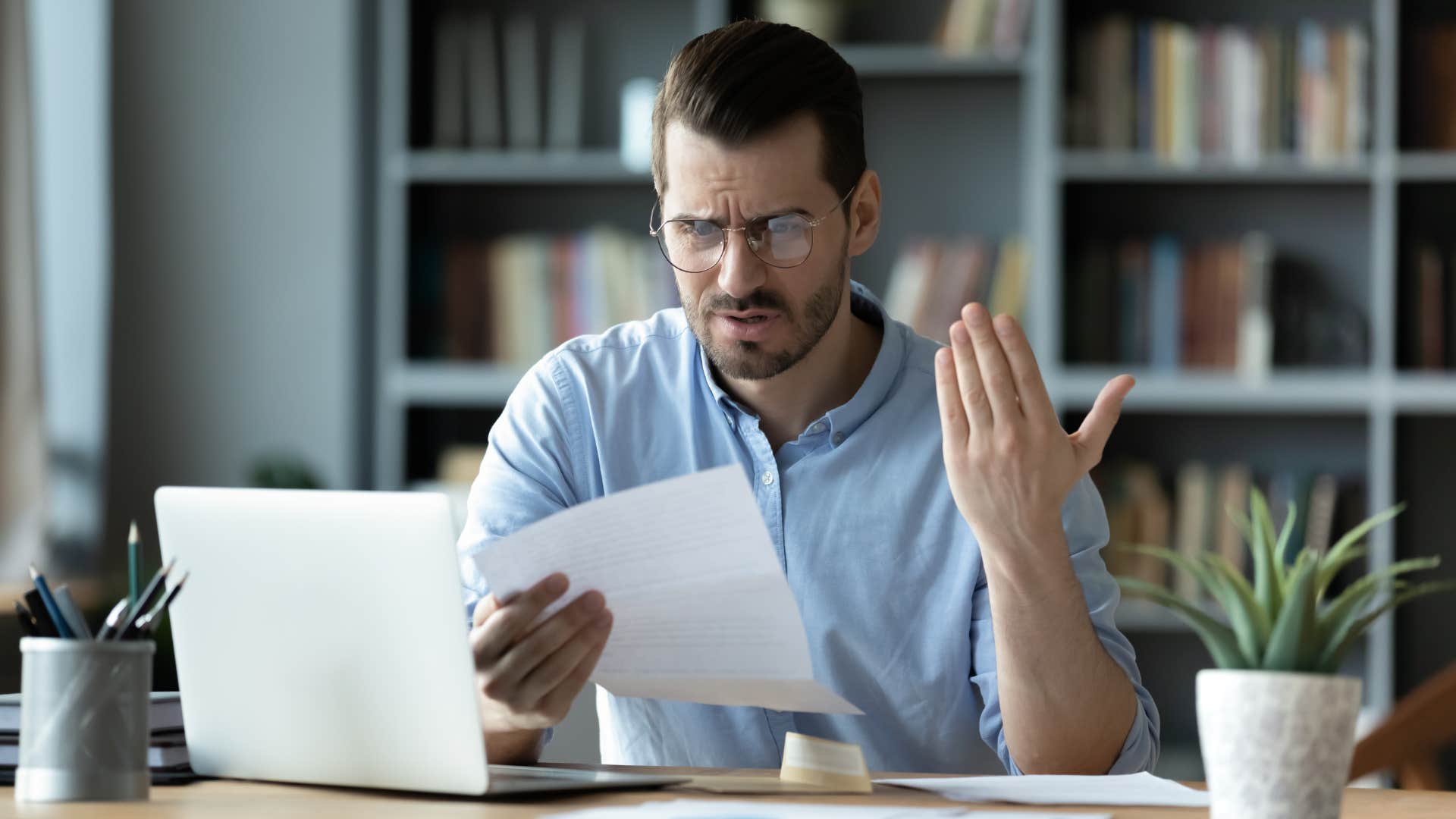 irritated man looking at paper feeling inefficient