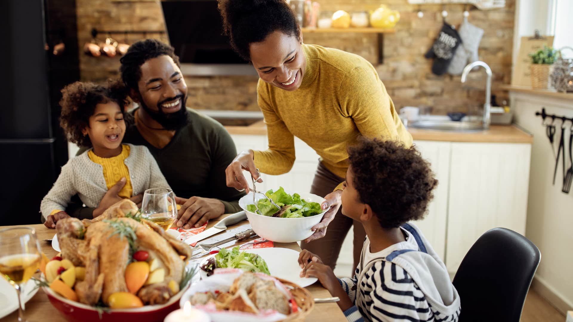 hapy parents and children at table for meal showing way to model gratitude