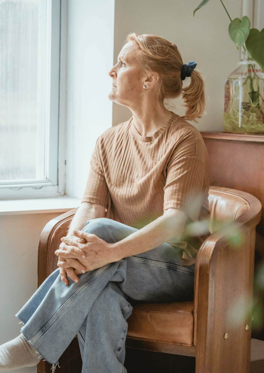 thoughtful middle age woman looking out of window