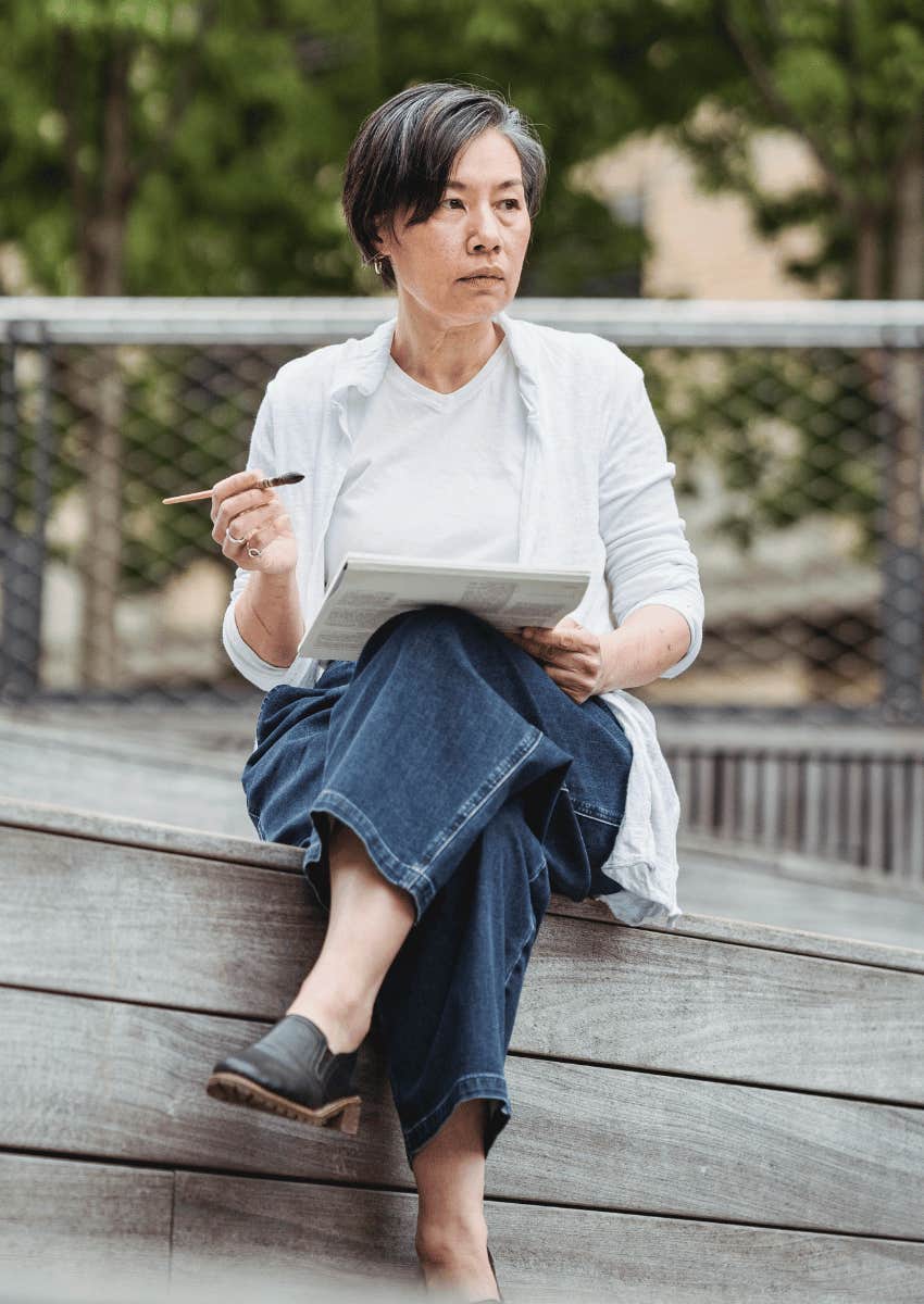 thoughtful older woman sitting outdoors