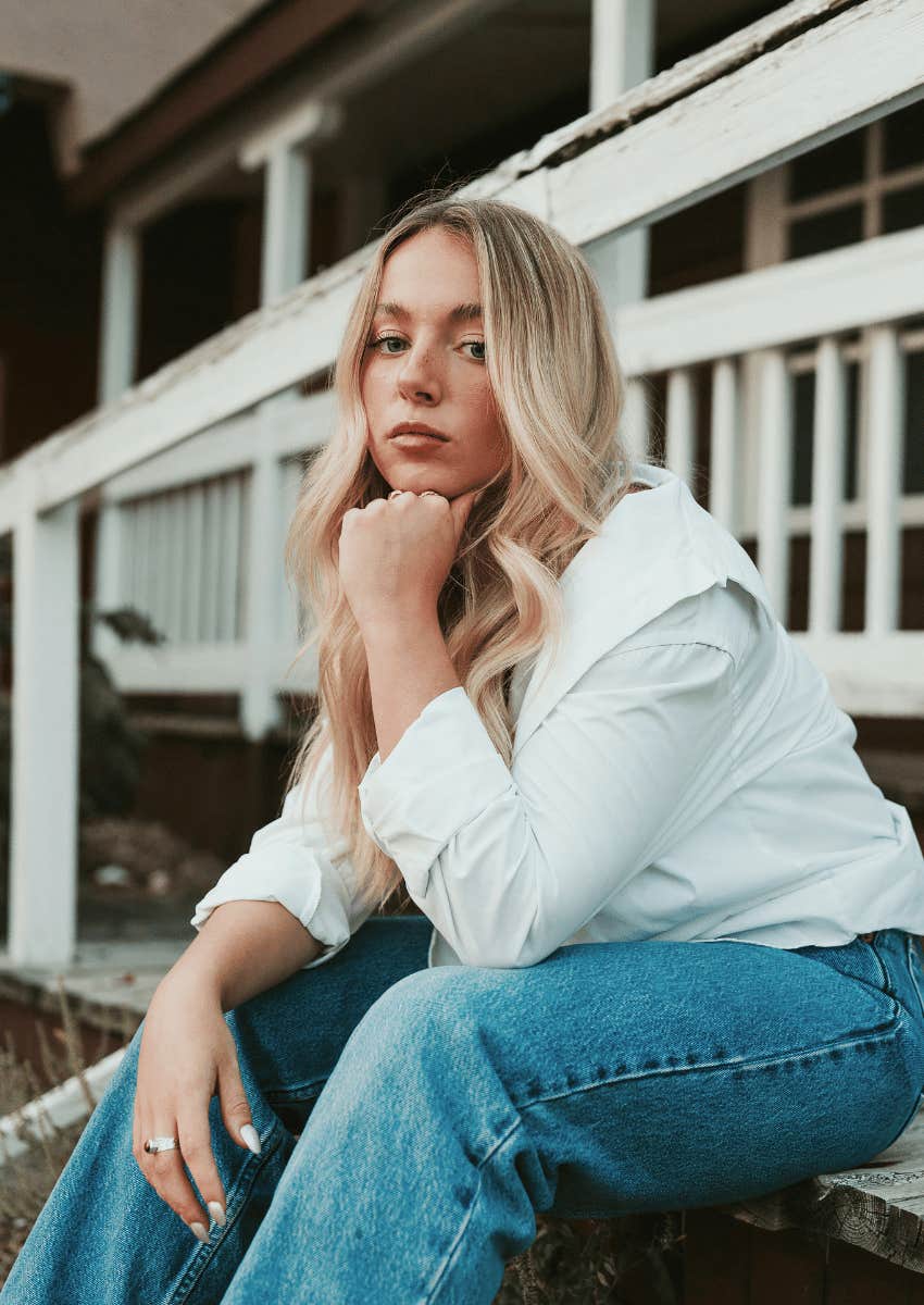 thoughtful serious woman sitting on stairs