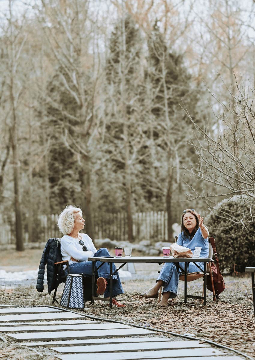 two middle age women sitting at table together