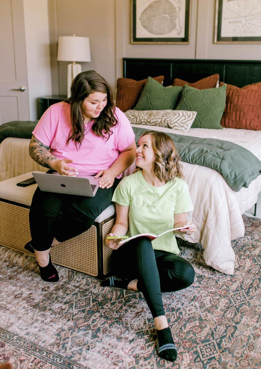 two woman sitting together in their bedroom