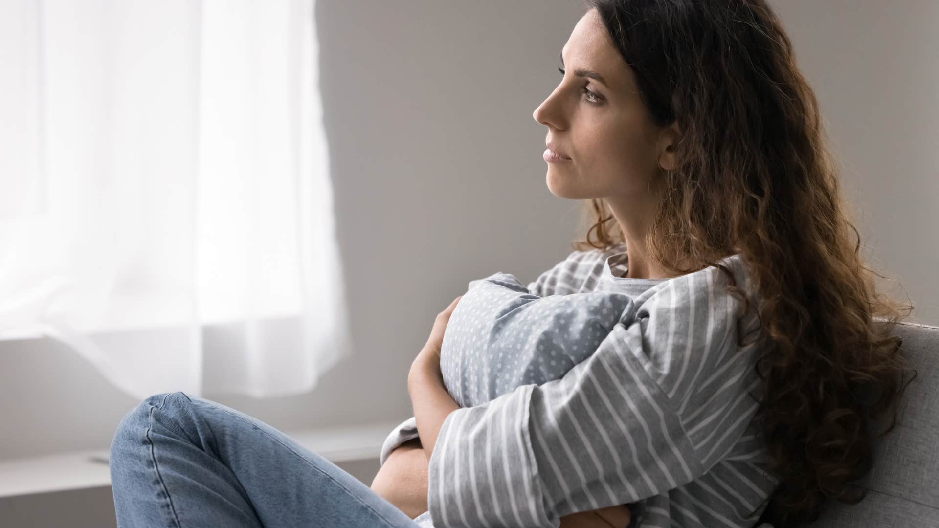 woman reflecting deeply on couch about the fact that Most of your childhood friendships were based on proximity, not compatibility