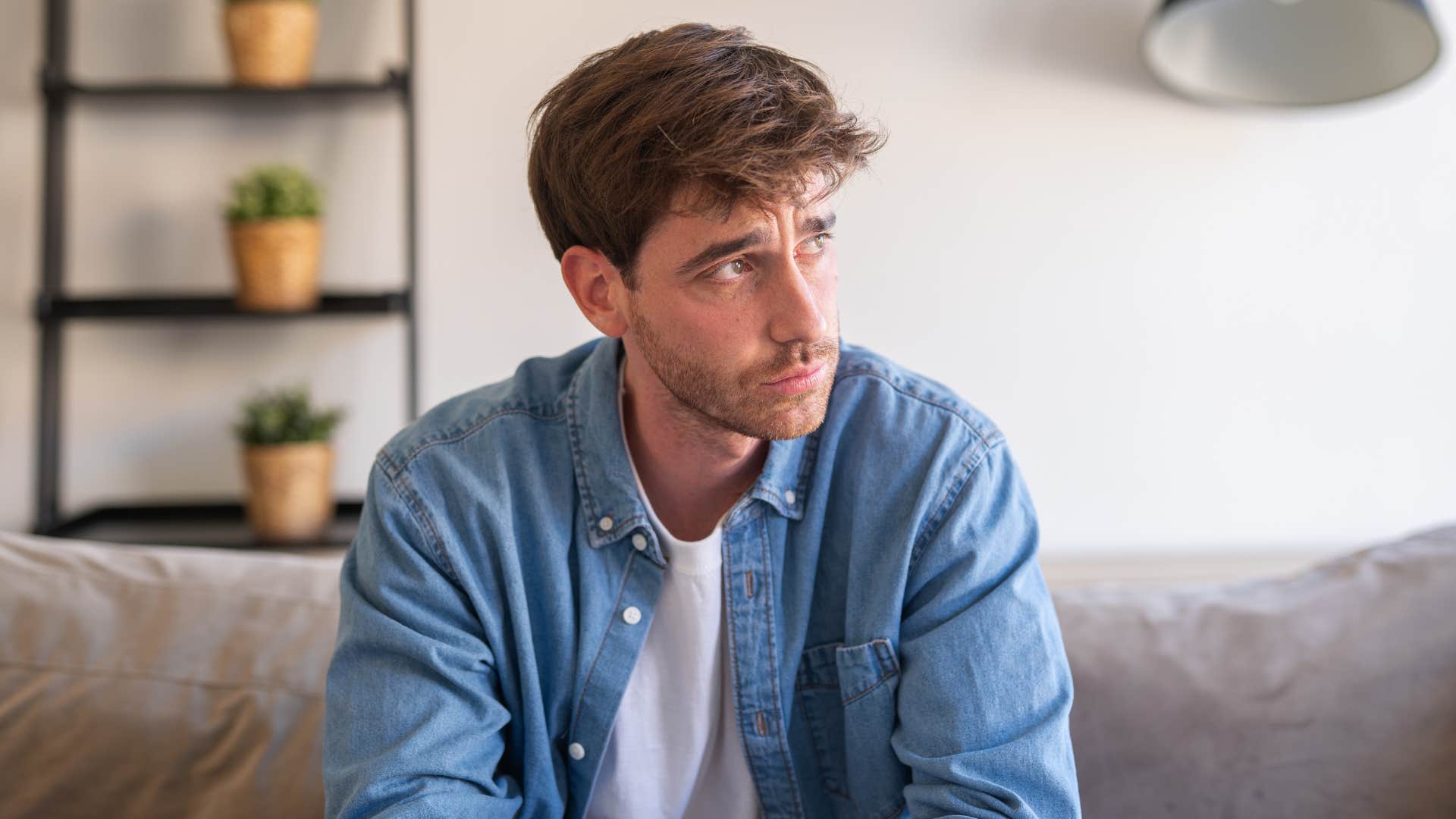 man in white shirt showing signs of dissatisfaction as he is romanticizing the past