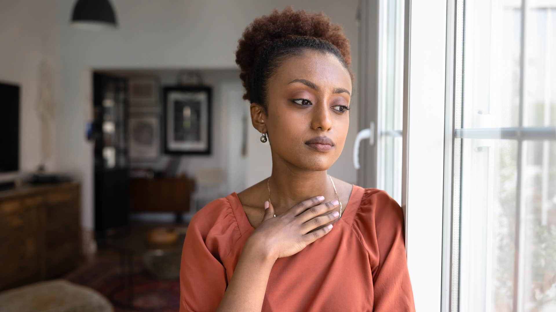 woman in orange shirt regrets the thing she didn't do the most as she deeply reflects