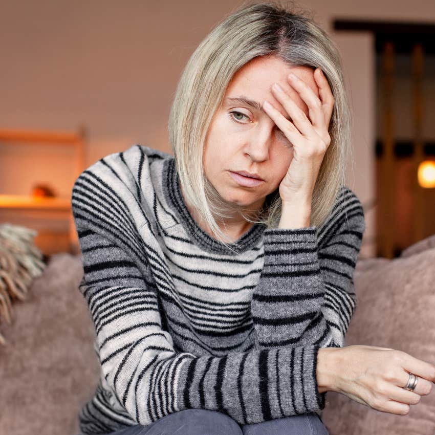 depressed woman sitting on couch at home