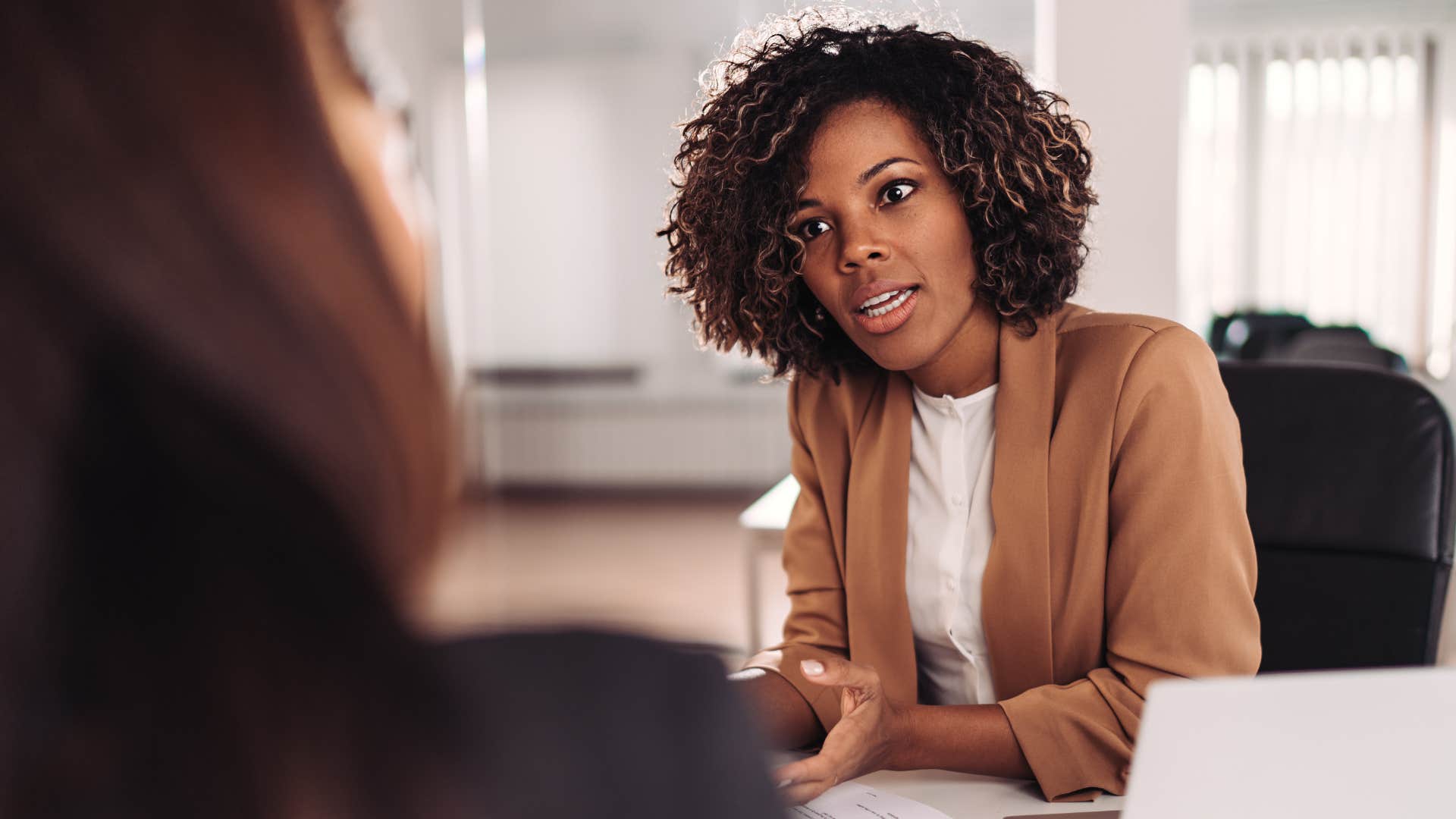 Woman being corrected publicly by her boss at work.