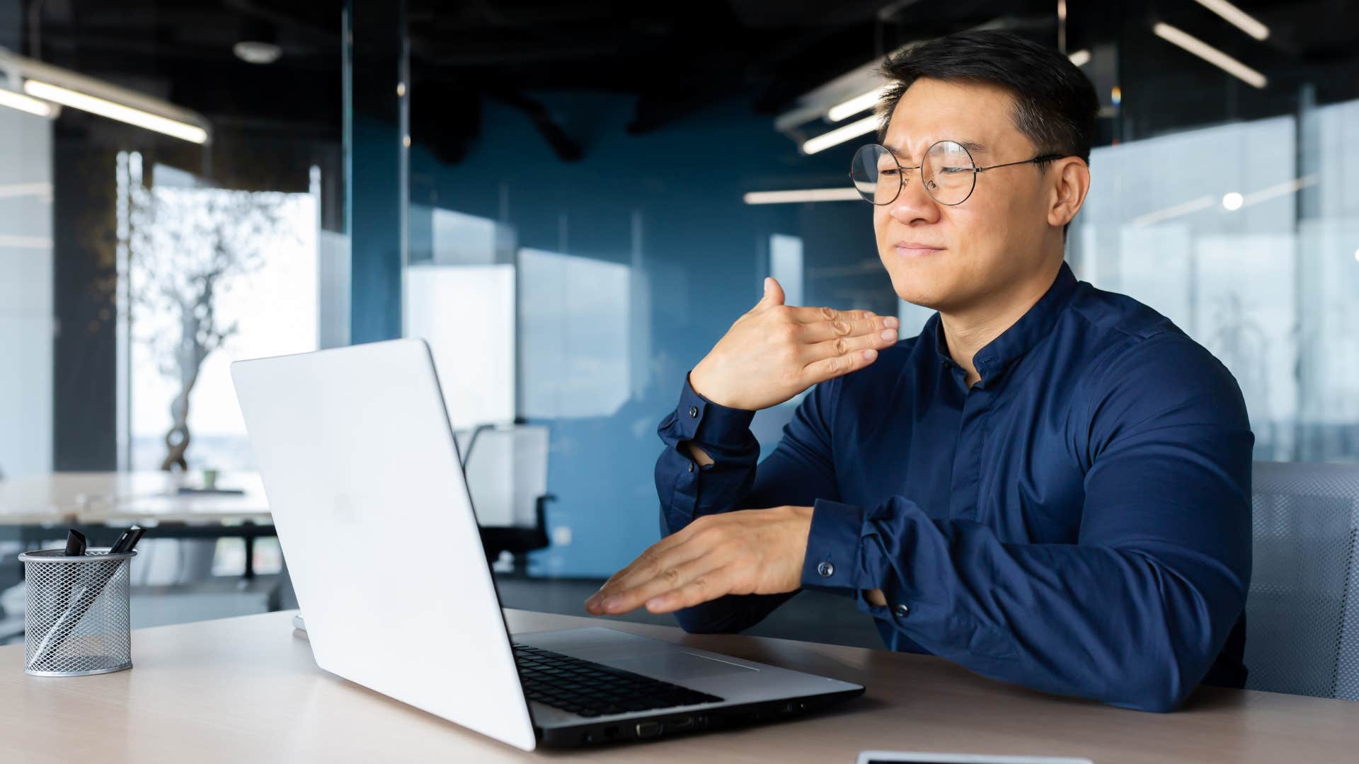 Man who hates being put on the spot in meetings on his laptop.